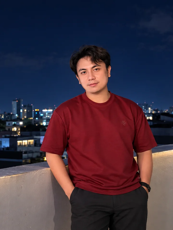 Jeffrey Brian Castro on a rooftop at night, the city skyline lit behind him.